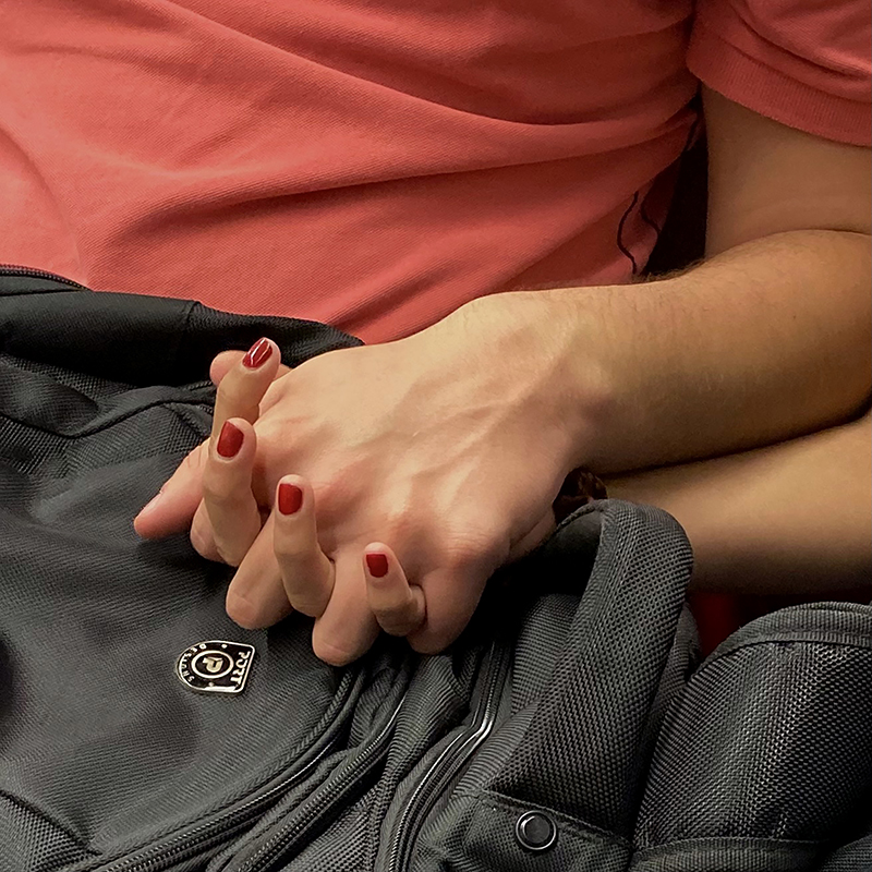 Mãos de casal entrelaçadas.