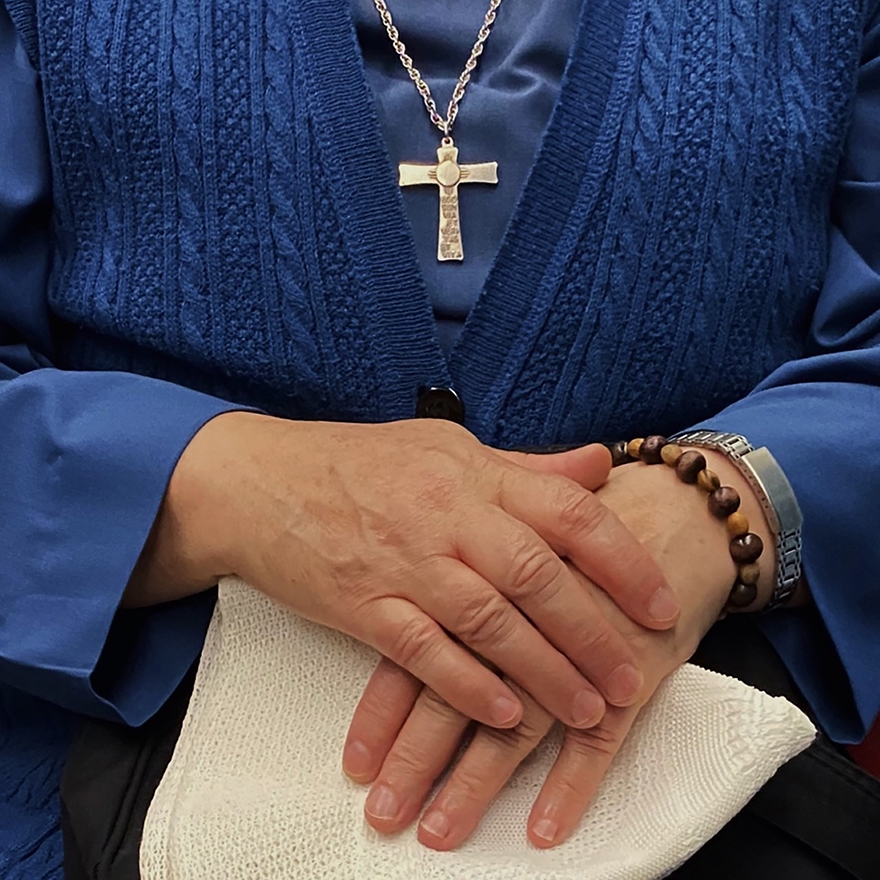 Mãos de pessoa idosa entrelaçadas.