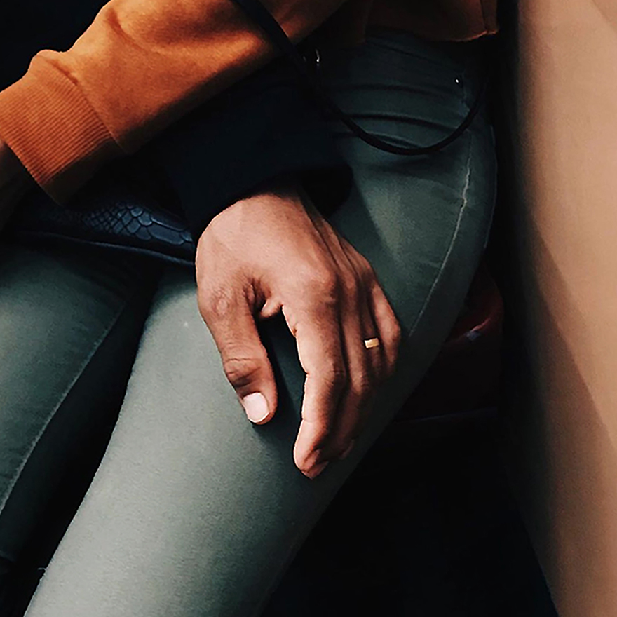 Mão de homem pousada na perna de mulher.